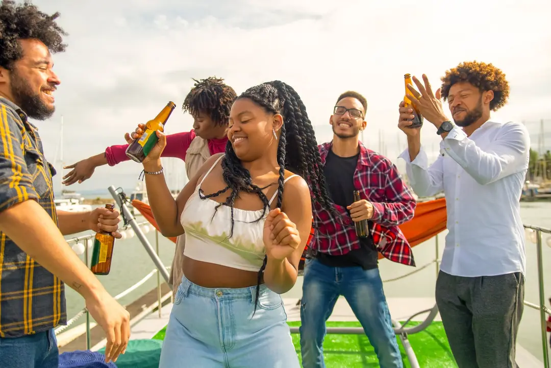 Amigos dançando e brindando a bordo